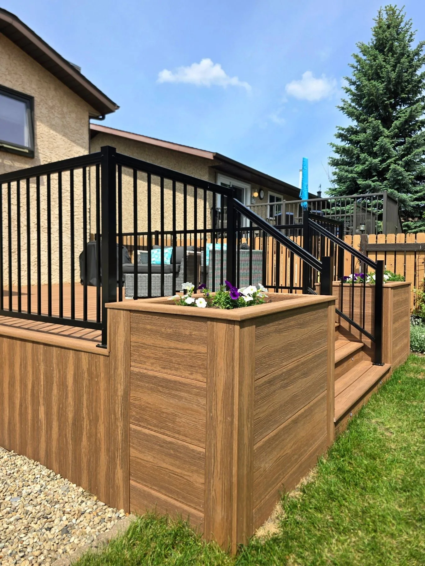 Eva-Last composite deck with built-in planters and stair lighting in Mill Woods